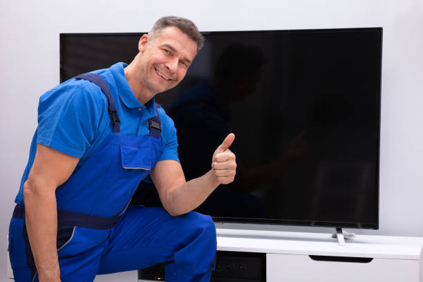 Smiling Mature Technician Showing Thumb Up In Front Of Television Smiling Mature Technician Showing Thumb Up In Front Of Television